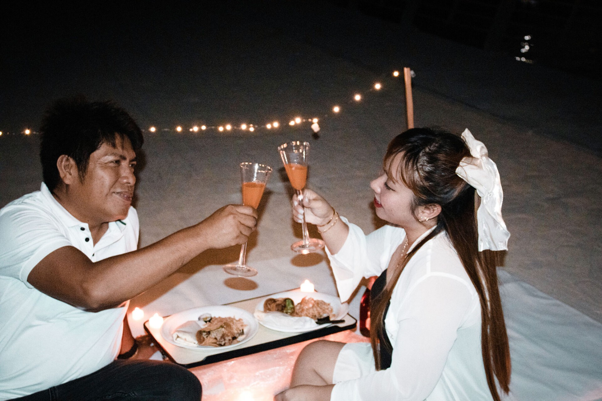 Beachside candlelit dinner toast