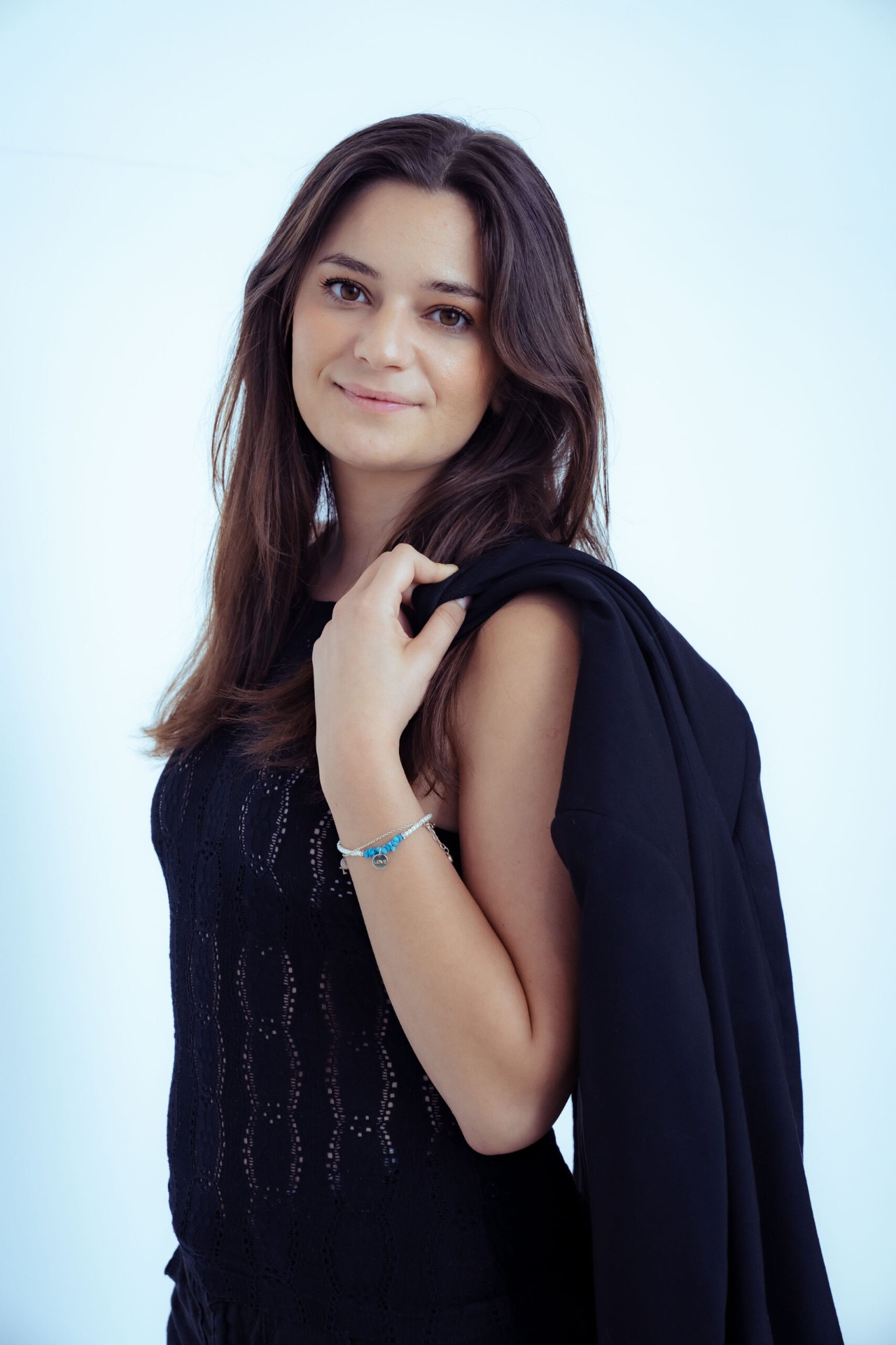 Smiling studio portrait with blazer over shoulder