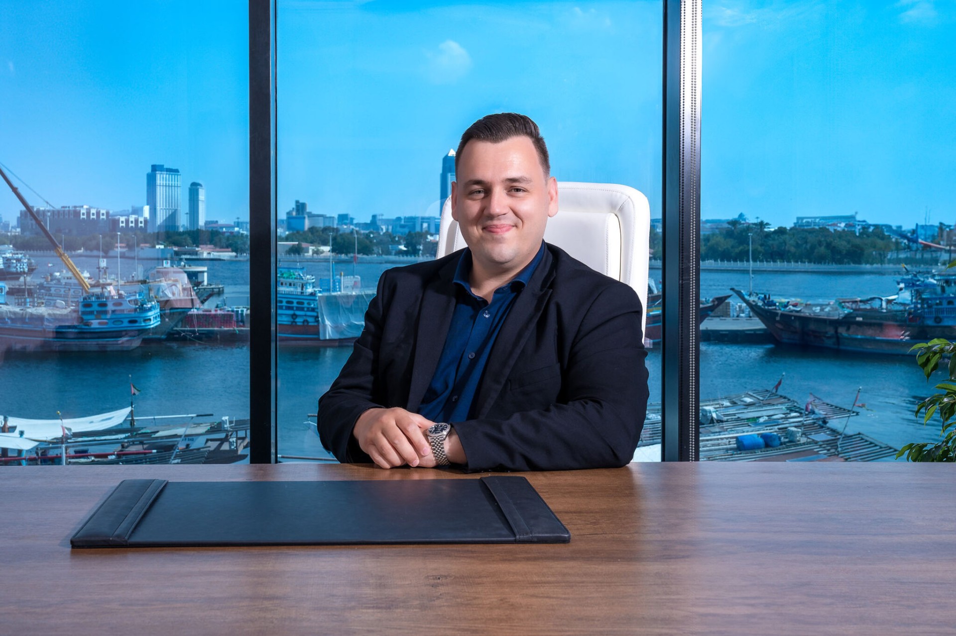 Executive portrait at desk with marina view