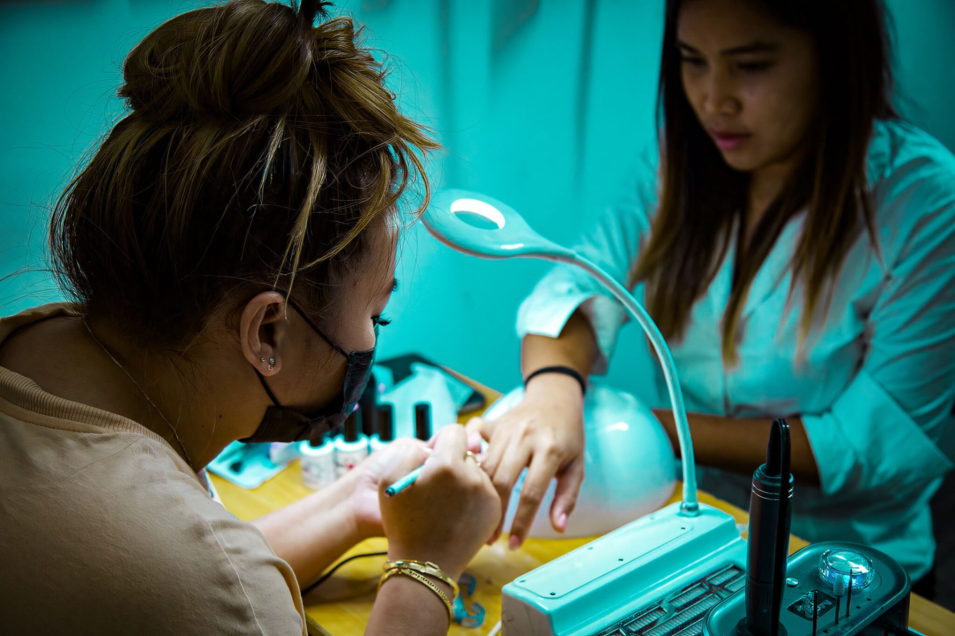 Nail salon teal-lit candid